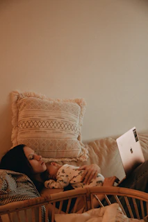 a woman laying on a bed with a laptop