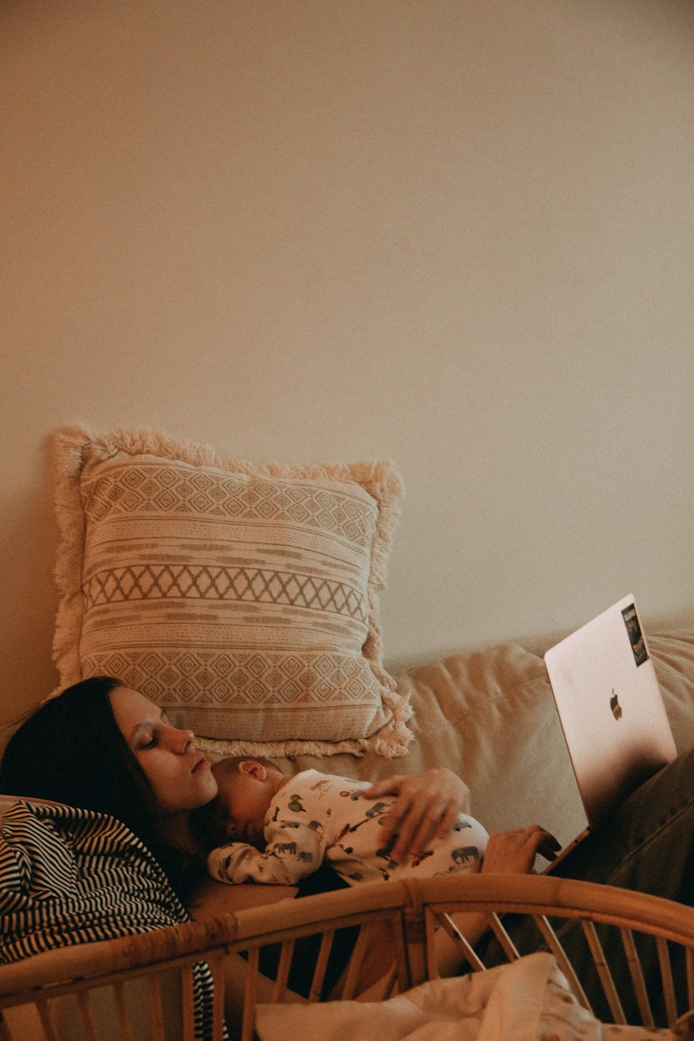 a woman laying on a bed with a laptop