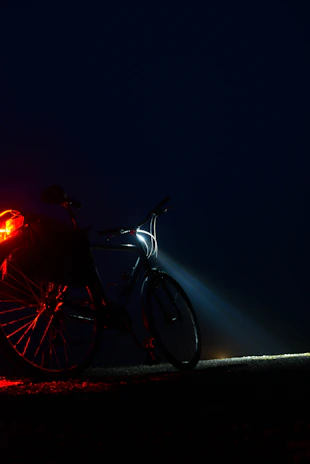 Bright front and rear lights mounted on an electric bike, illuminating a nighttime street.