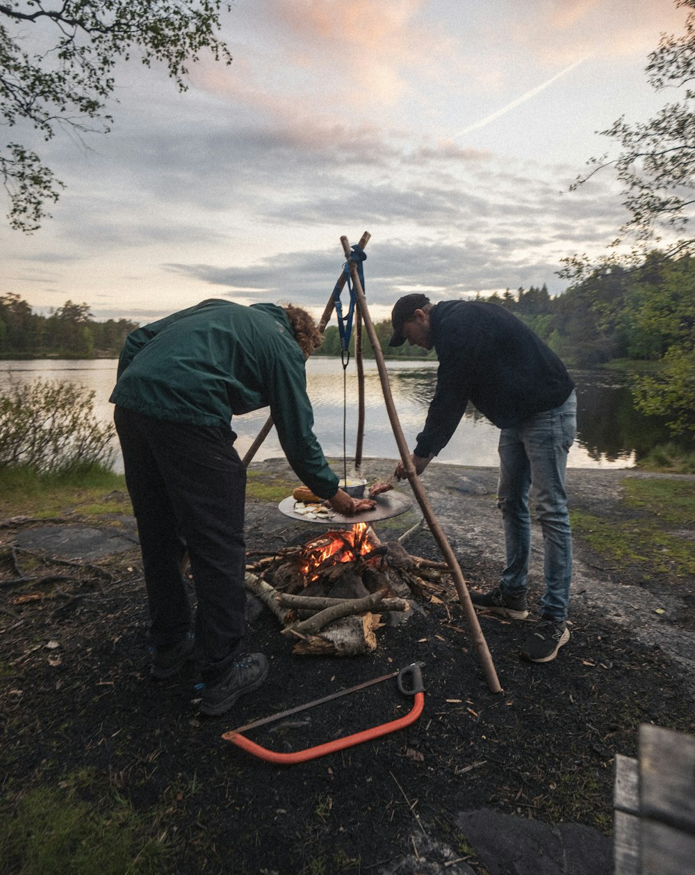 a couple of men standing next to a fire