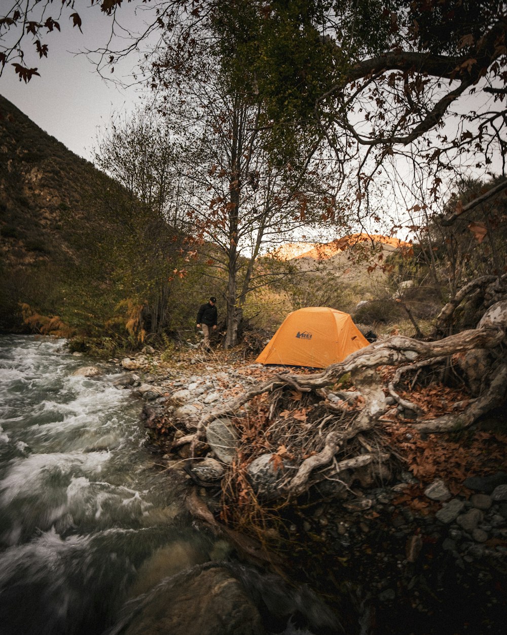 a tent pitched up next to a river