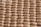 A close-up view of a honeycomb structure made from cardboard, featuring a repeating geometric pattern. The cells are hexagonal and crafted from a light brown paper material, giving a textured appearance with shadows that enhance the depth and structure.