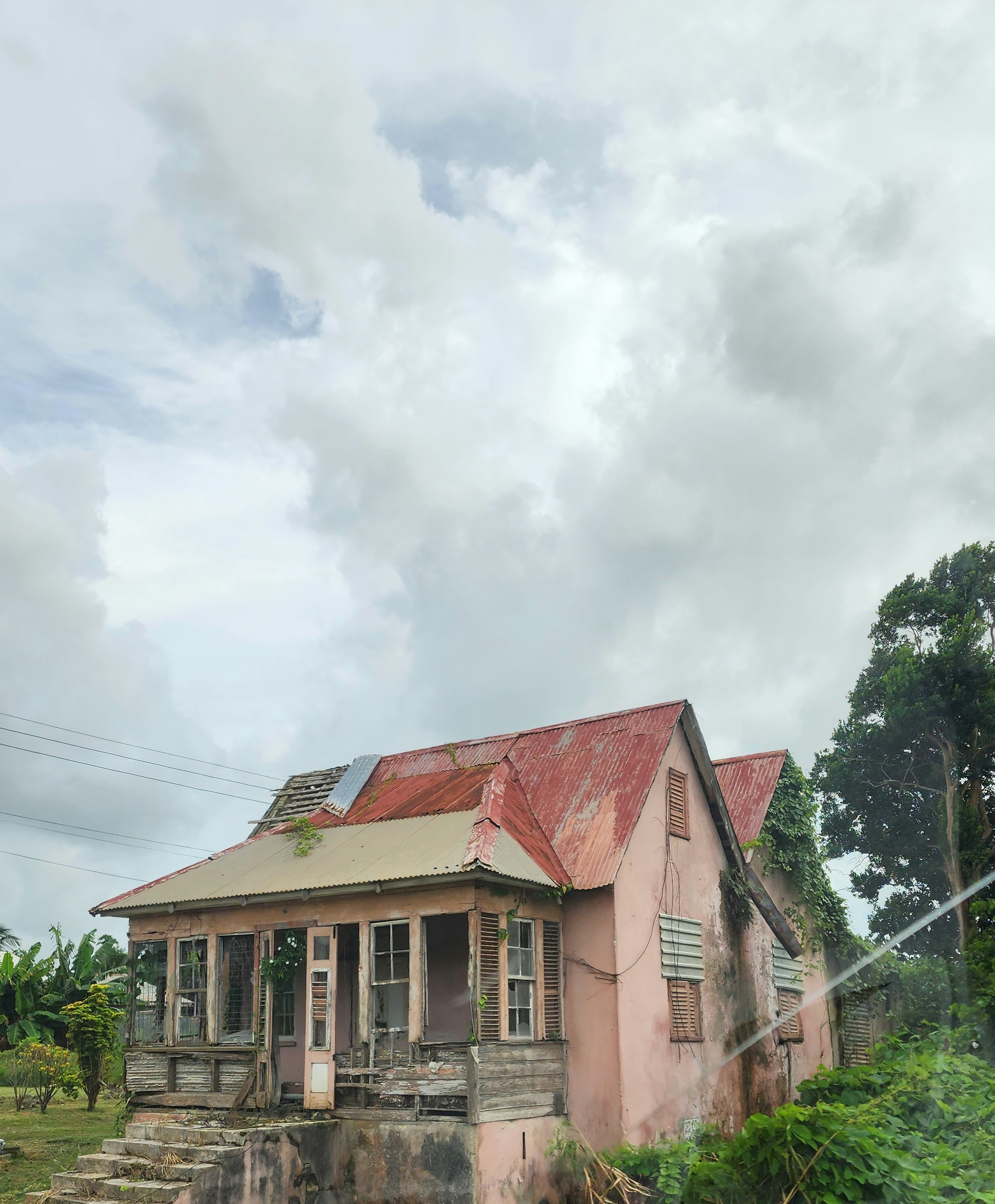 an old pink house with a rusty roof