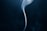A smooth, delicate wisp of smoke rises gently against a dark background, creating a sense of movement and fluidity.