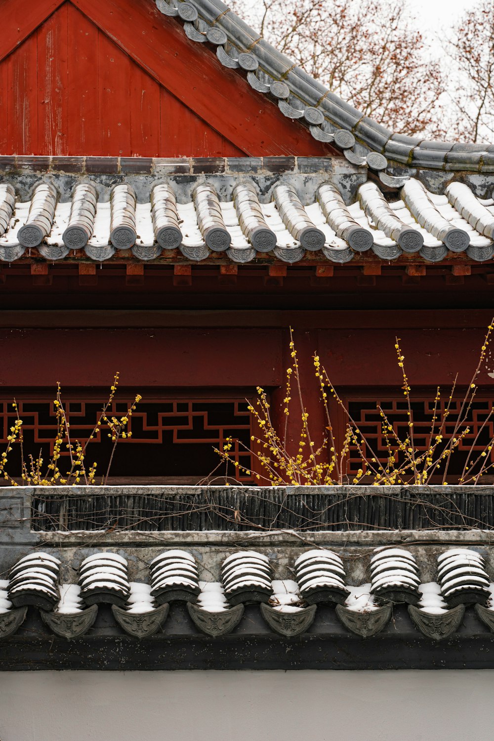 a building with a red roof and a plant in front of it