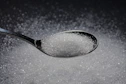 a spoon filled with sugar on top of a table