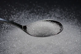 a spoon filled with sugar on top of a table