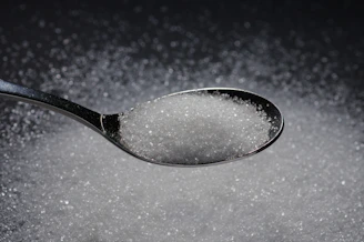 a spoon filled with sugar on top of a table