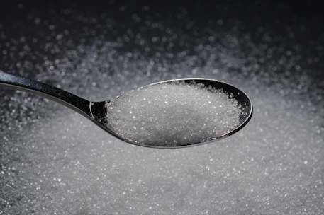 a spoon filled with sugar on top of a table