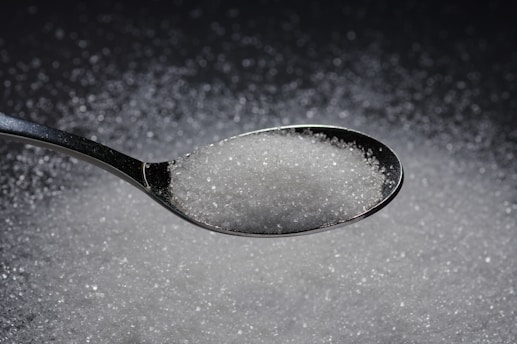 a spoon filled with sugar on top of a table