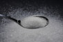 a spoon filled with sugar on top of a table