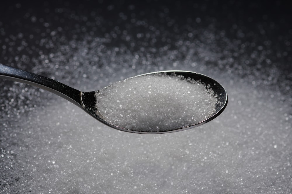 une cuillère remplie de sucre sur une table