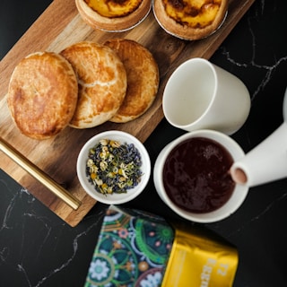 An inviting flat lay of various dry fruits and snacks with a cup of herbal tea on a linen cloth.