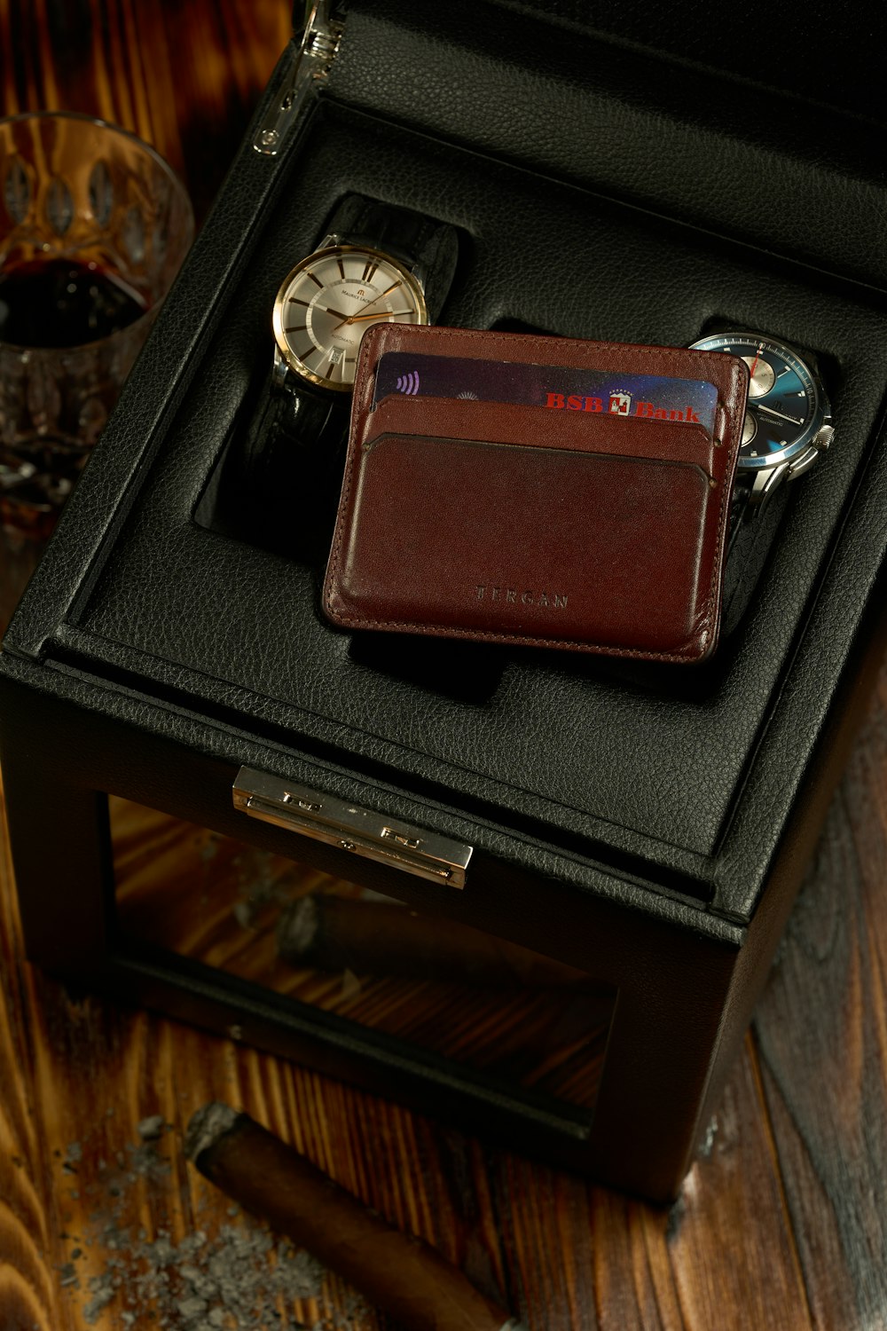 a wallet and watch in a black box