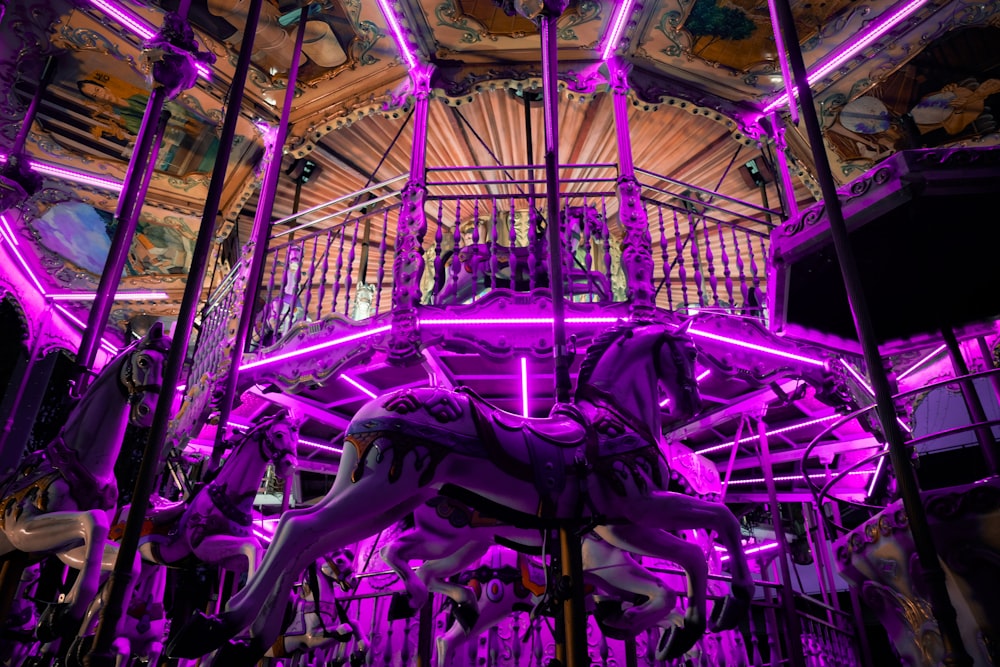 a carousel is lit up with purple lights