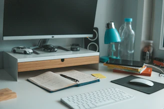 a desk with a keyboard, mouse and monitor