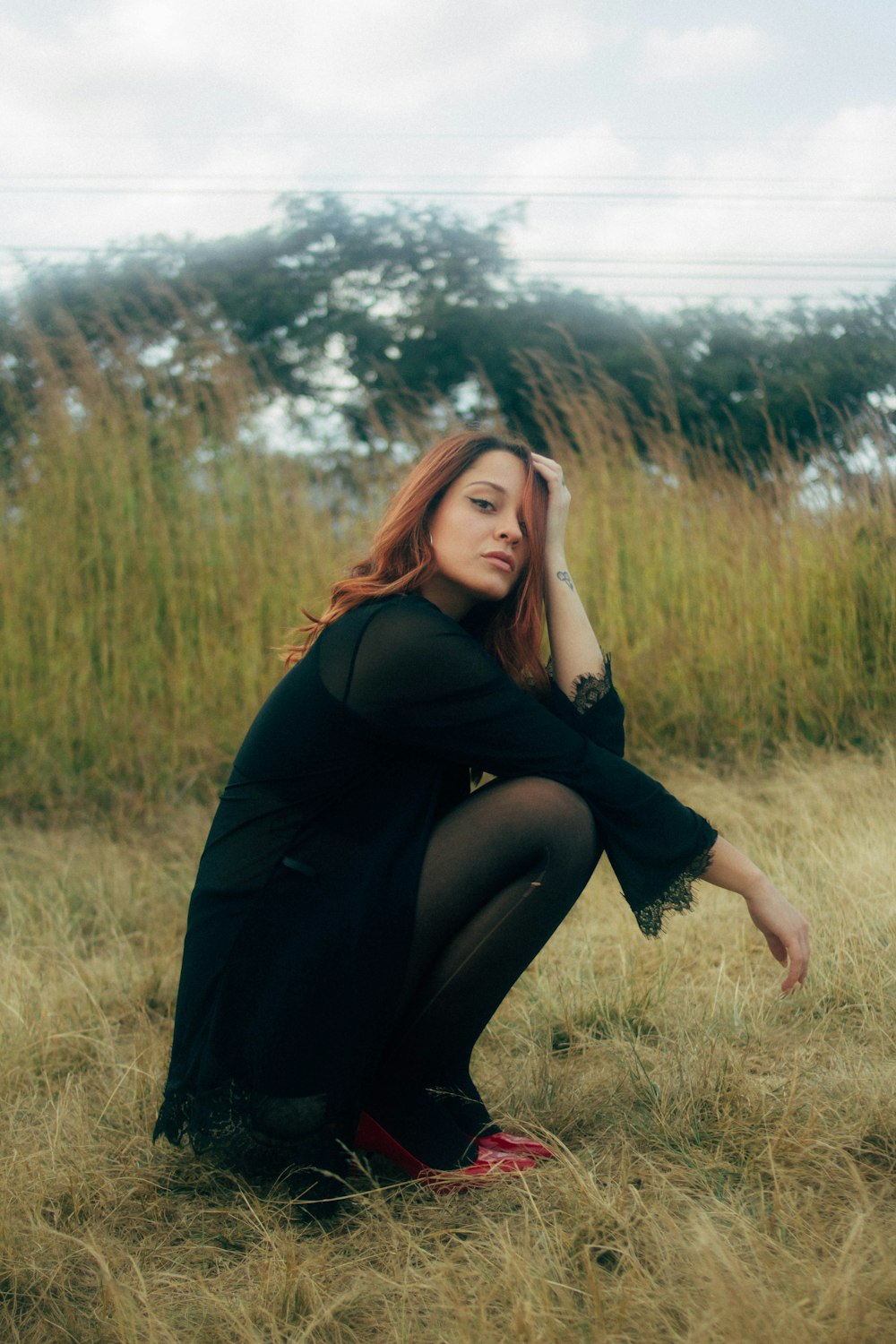 a woman sitting in a field of tall grass