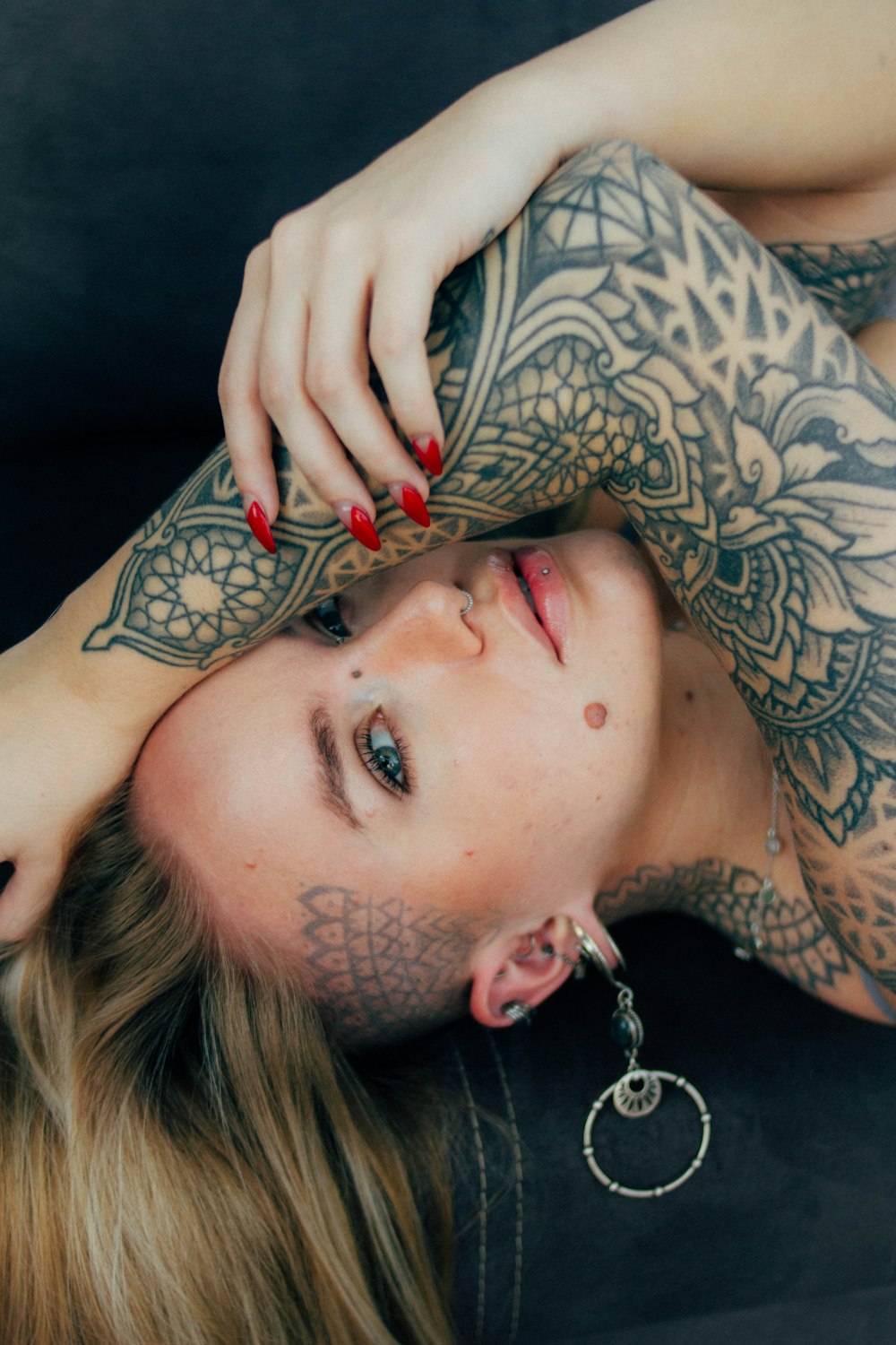 a woman with tattoos laying on a couch