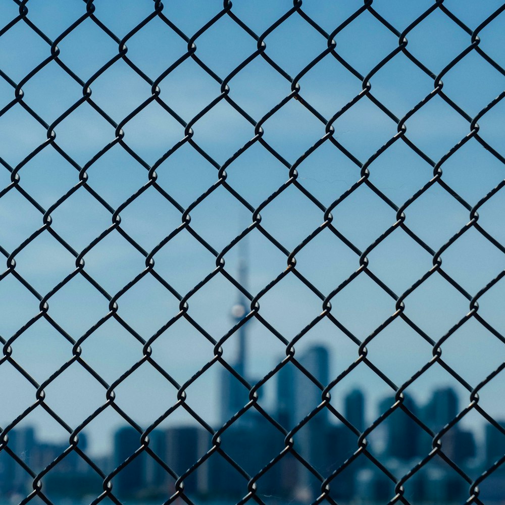 a view of a city through a chain link fence