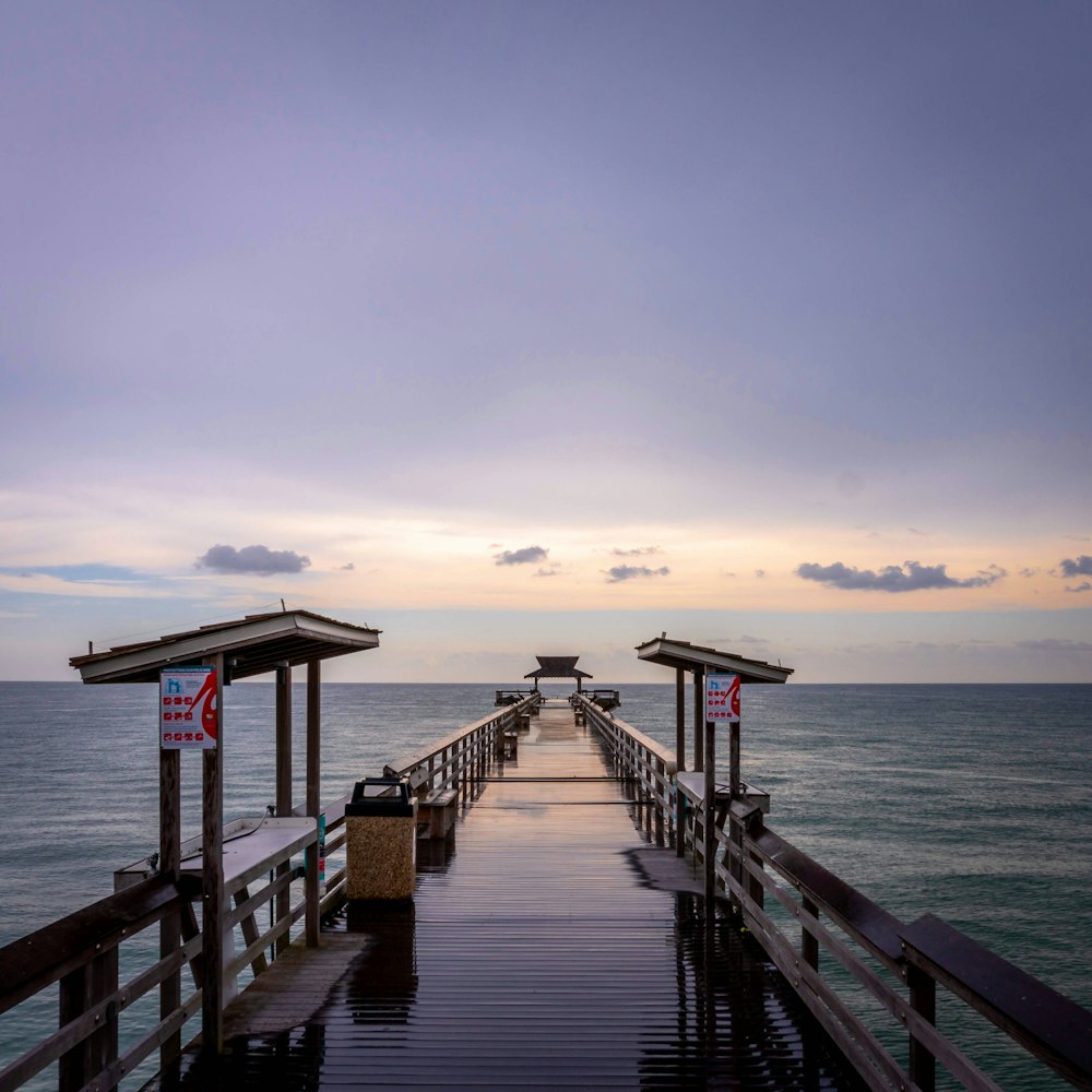 a long pier stretches out into the ocean