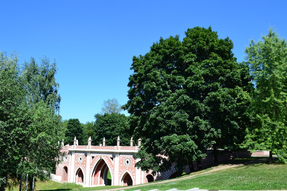 a park with a bridge and trees on a sunny day