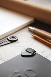 a cell phone sitting on top of a table next to a pen