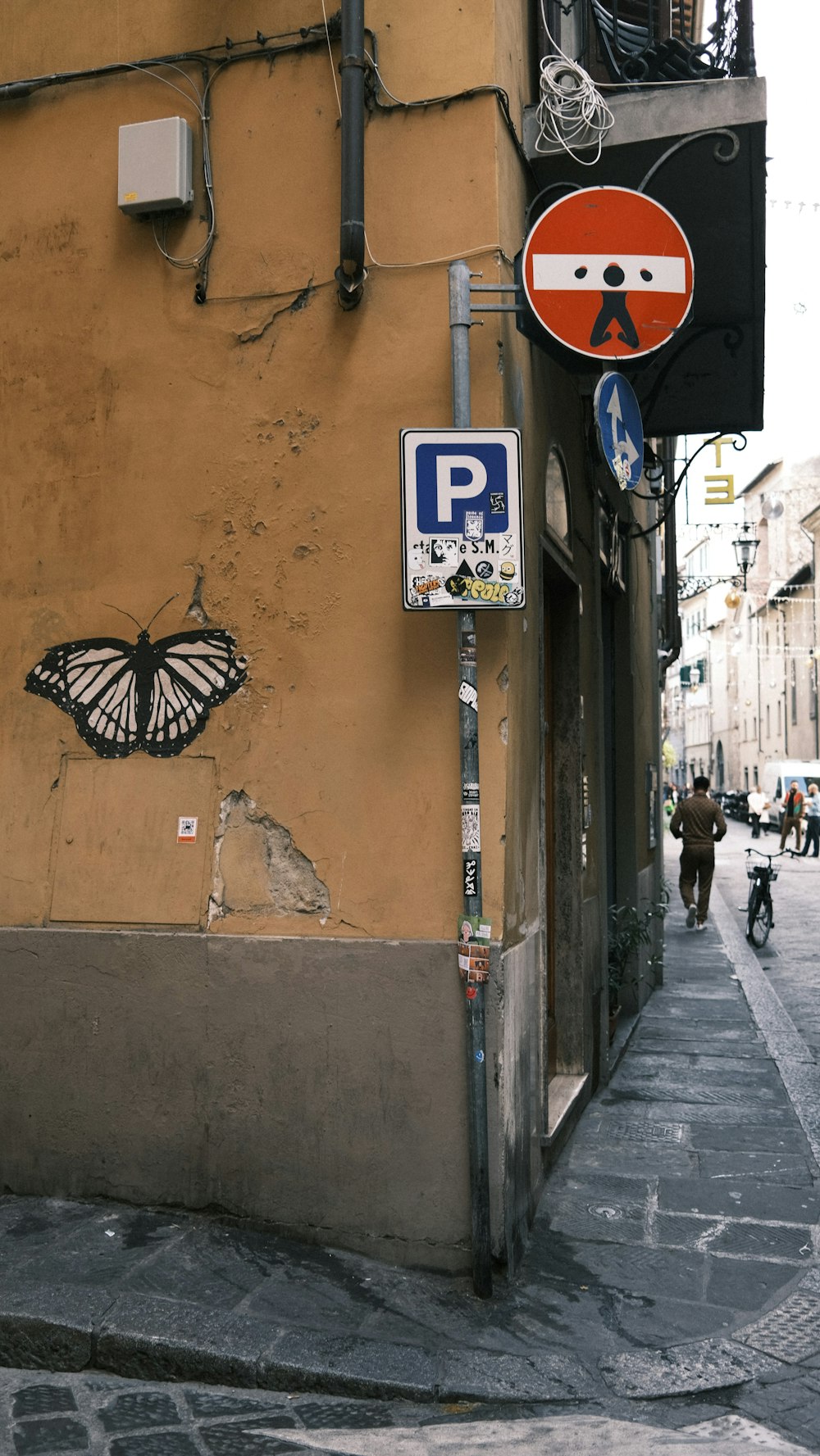 a street corner with a butterfly painted on the side of a building