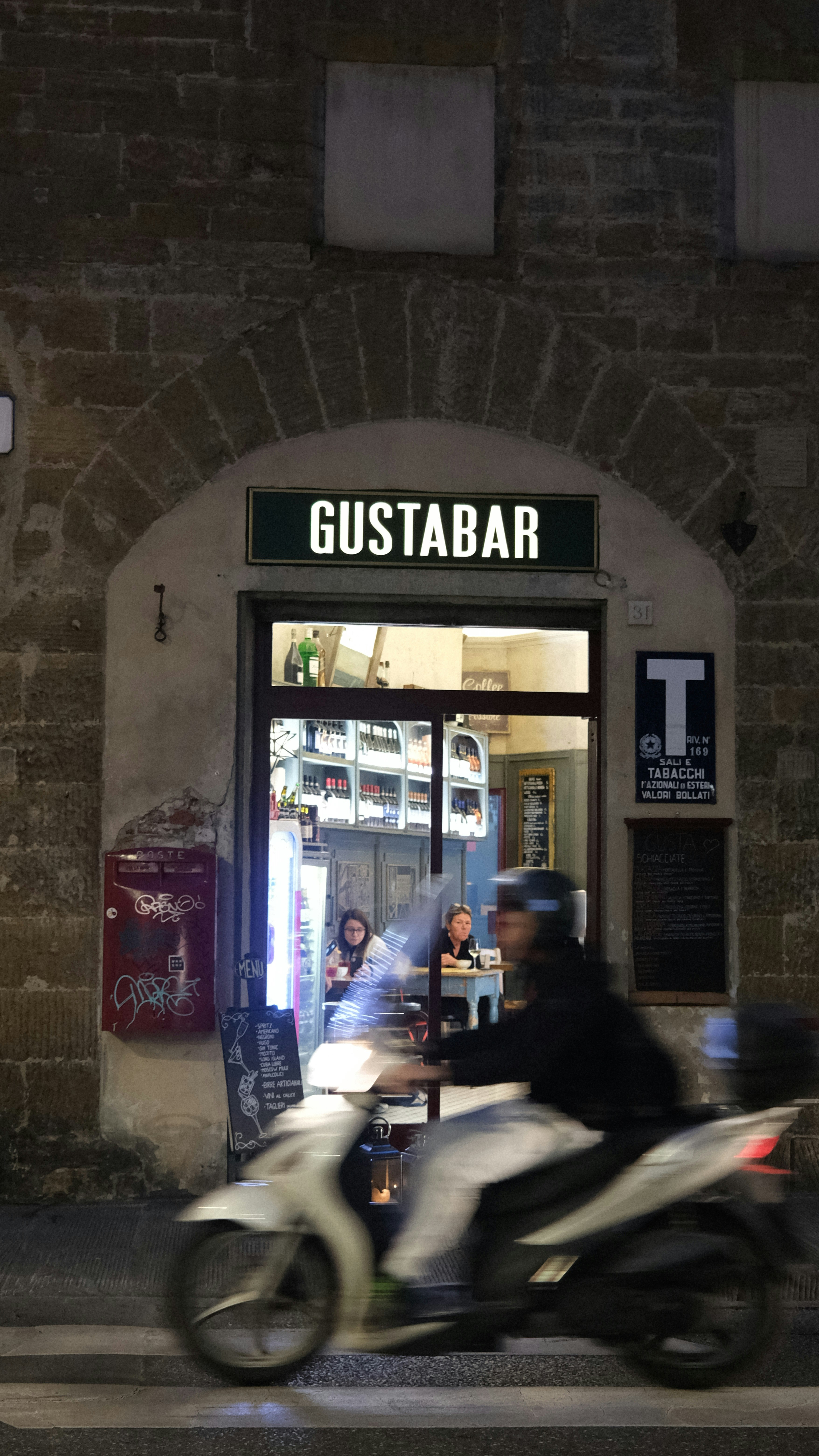 a man riding a motorcycle past a restaurant