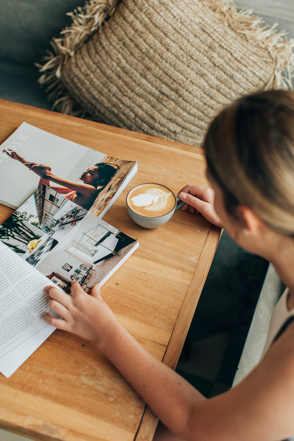 a woman sitting at a table with a cup of coffee