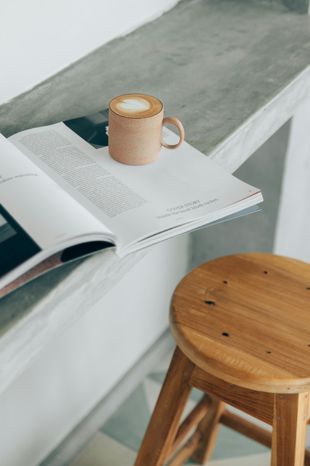 a cup of coffee sitting on top of a wooden stool