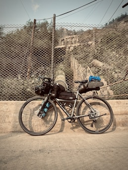 a bicycle is parked next to a fence
