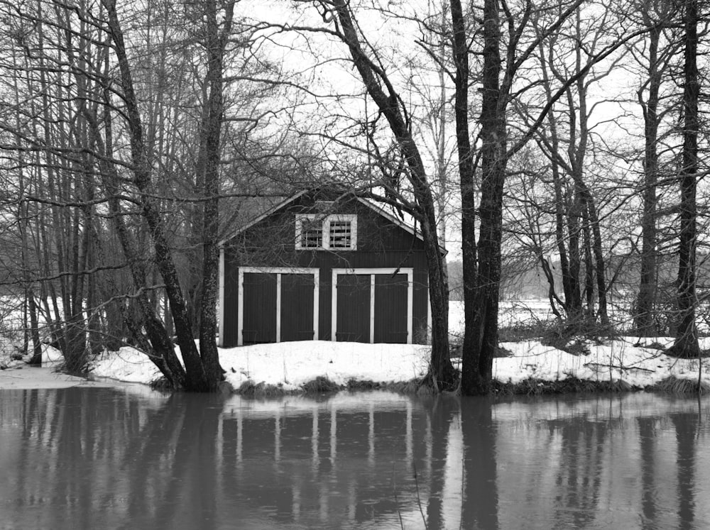 a black and white photo of a barn in the snow