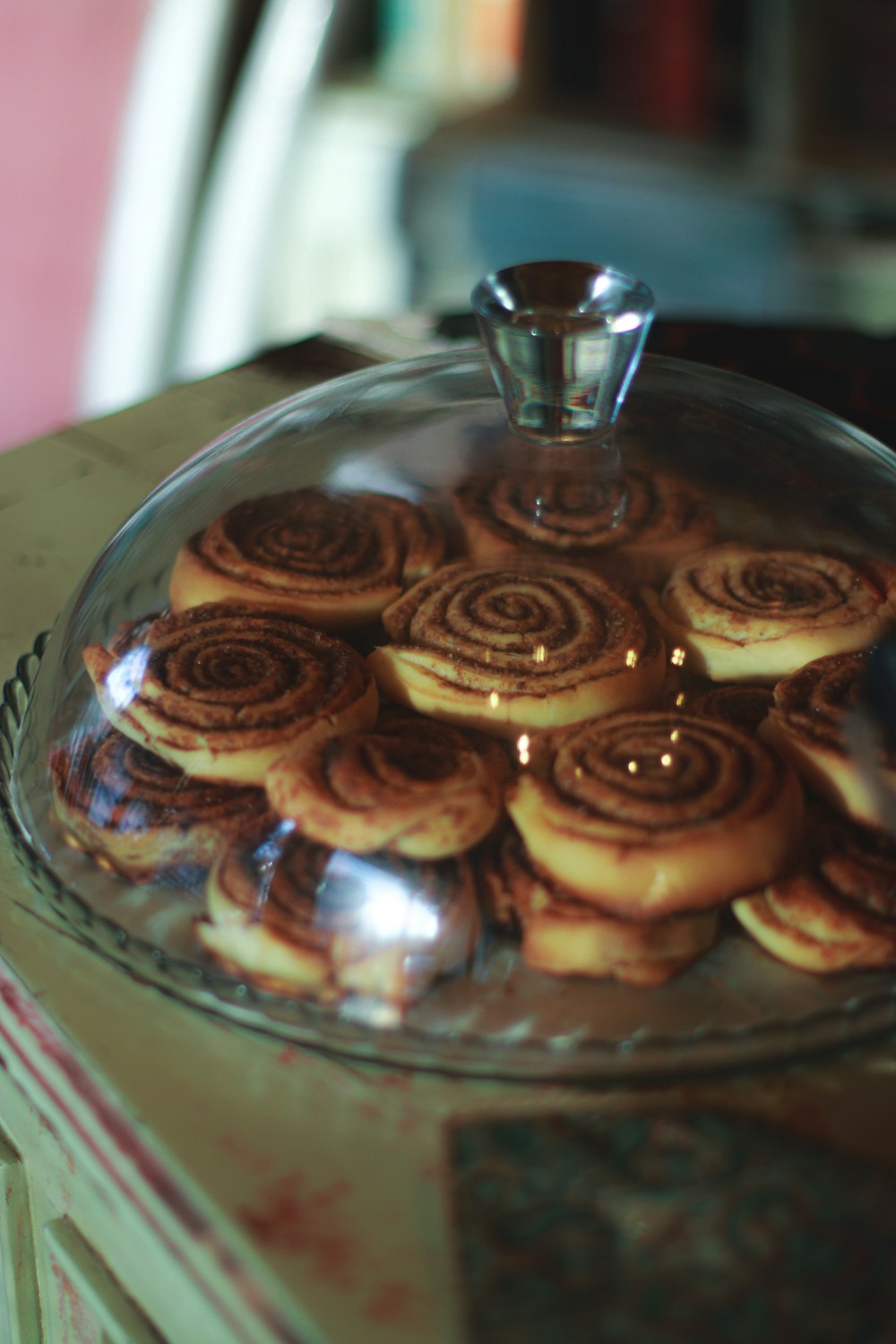 a glass platter filled with pastries on top of a table