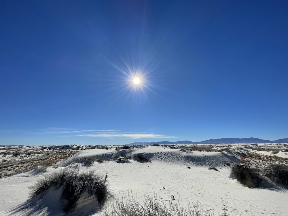 the sun shines brightly over a snowy landscape