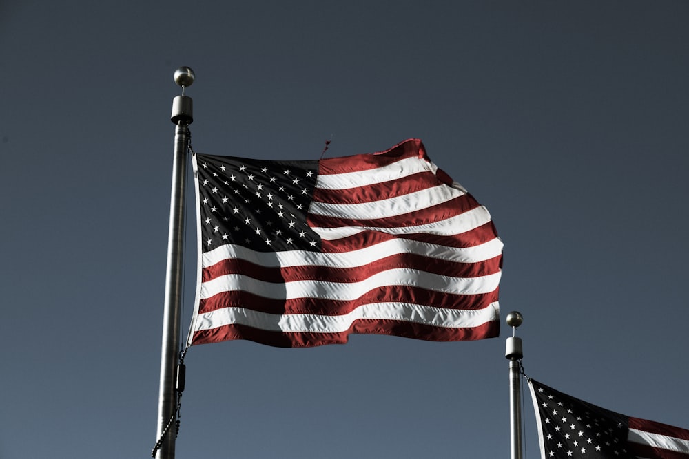 Dos banderas estadounidenses ondeando en el viento