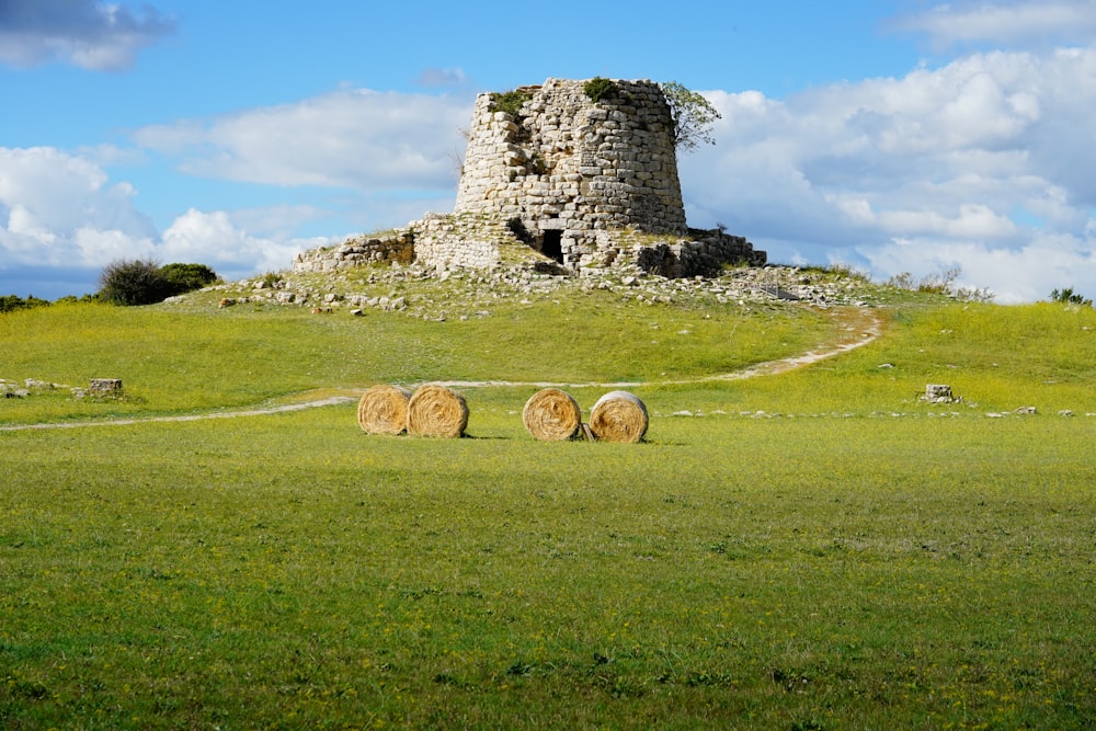 three round hay bales in a grassy field