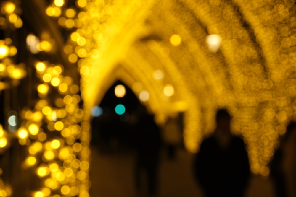 a group of people walking down a street covered in lights