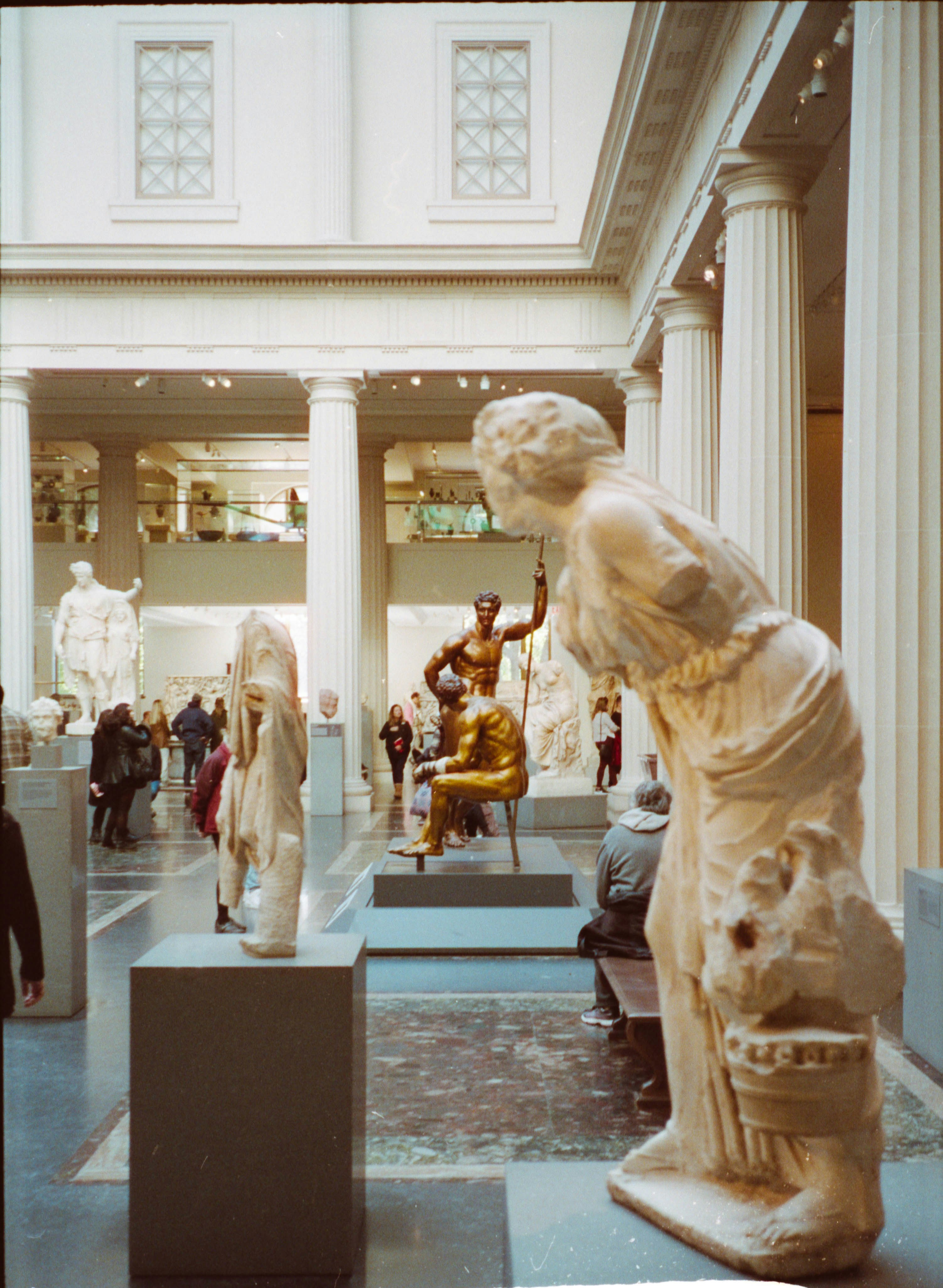 a group of people looking at statues in a museum