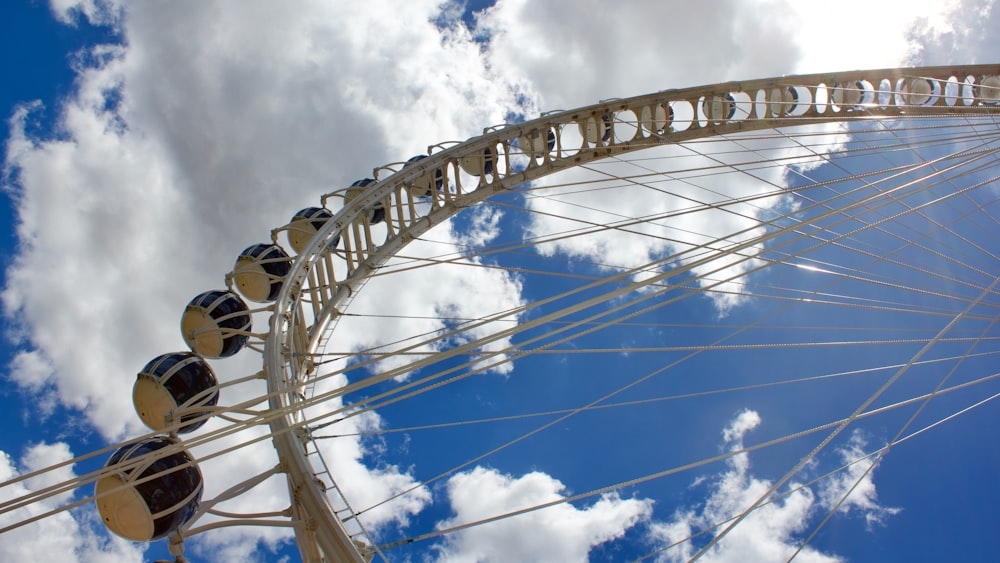 a ferris wheel with a sky background and clouds