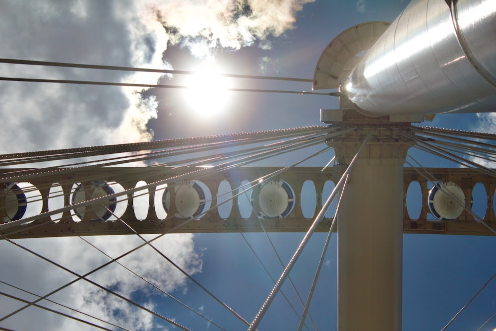 the sun is shining through the clouds over a bridge