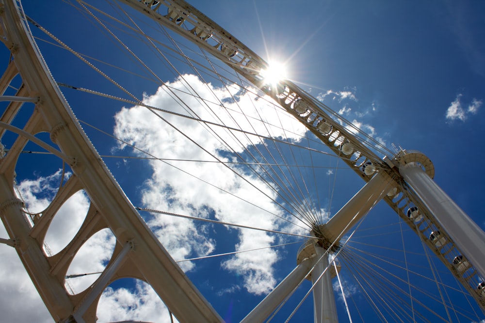 a ferris wheel with the sun shining through the clouds