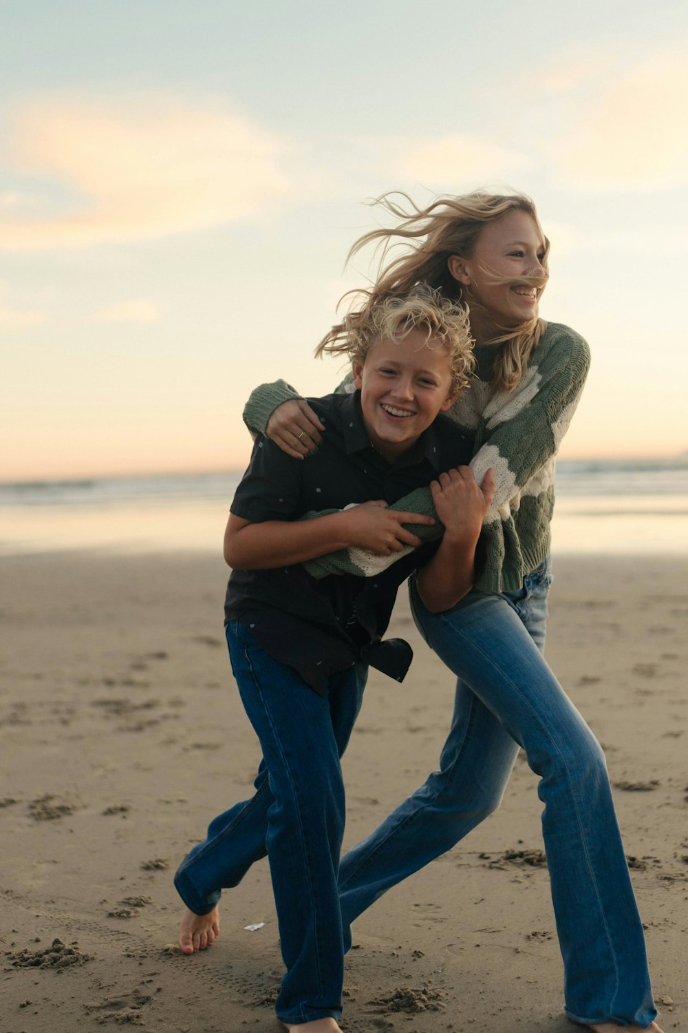 a woman holding a child on the beach