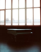 A dimly lit room with a vintage piano and scattered sheet music.
