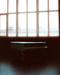 Dimly lit studio with a grand piano and scattered sheet music.