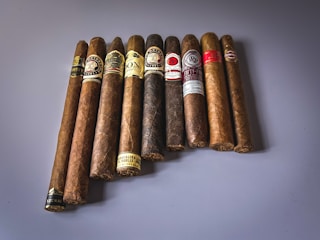 An assortment of machine-made cigars displayed in a rustic wooden box.
