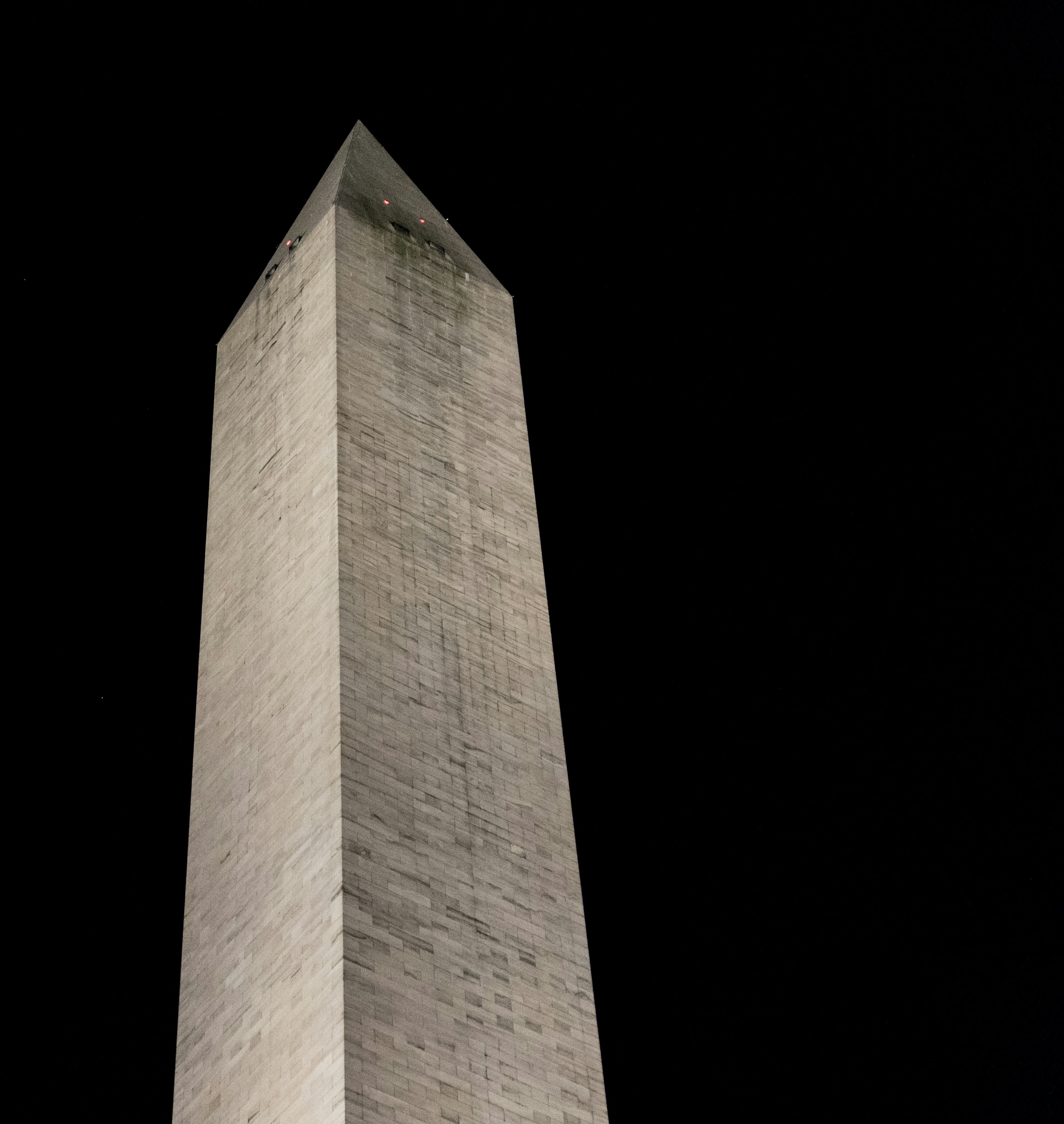 the washington monument is lit up at night