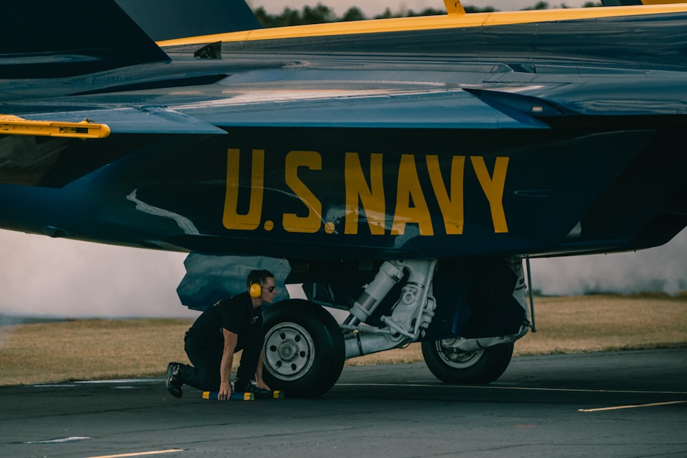 a man working on the nose of an airplane