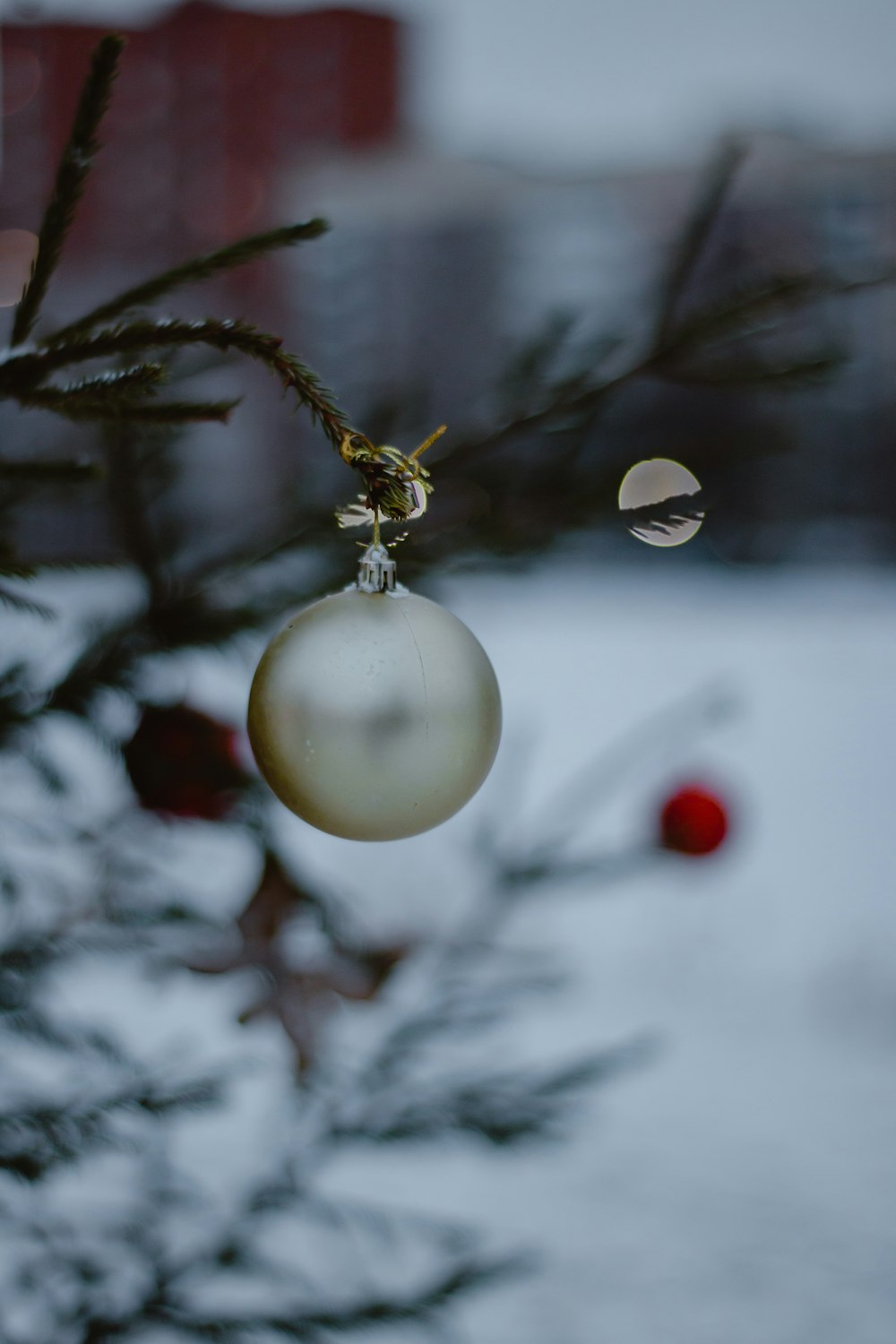 a white ornament hanging from a tree in the snow