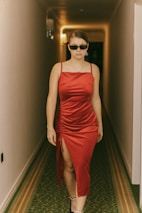 A sophisticated VIP escort in a classy evening dress walking confidently through a luxury hotel lobby.