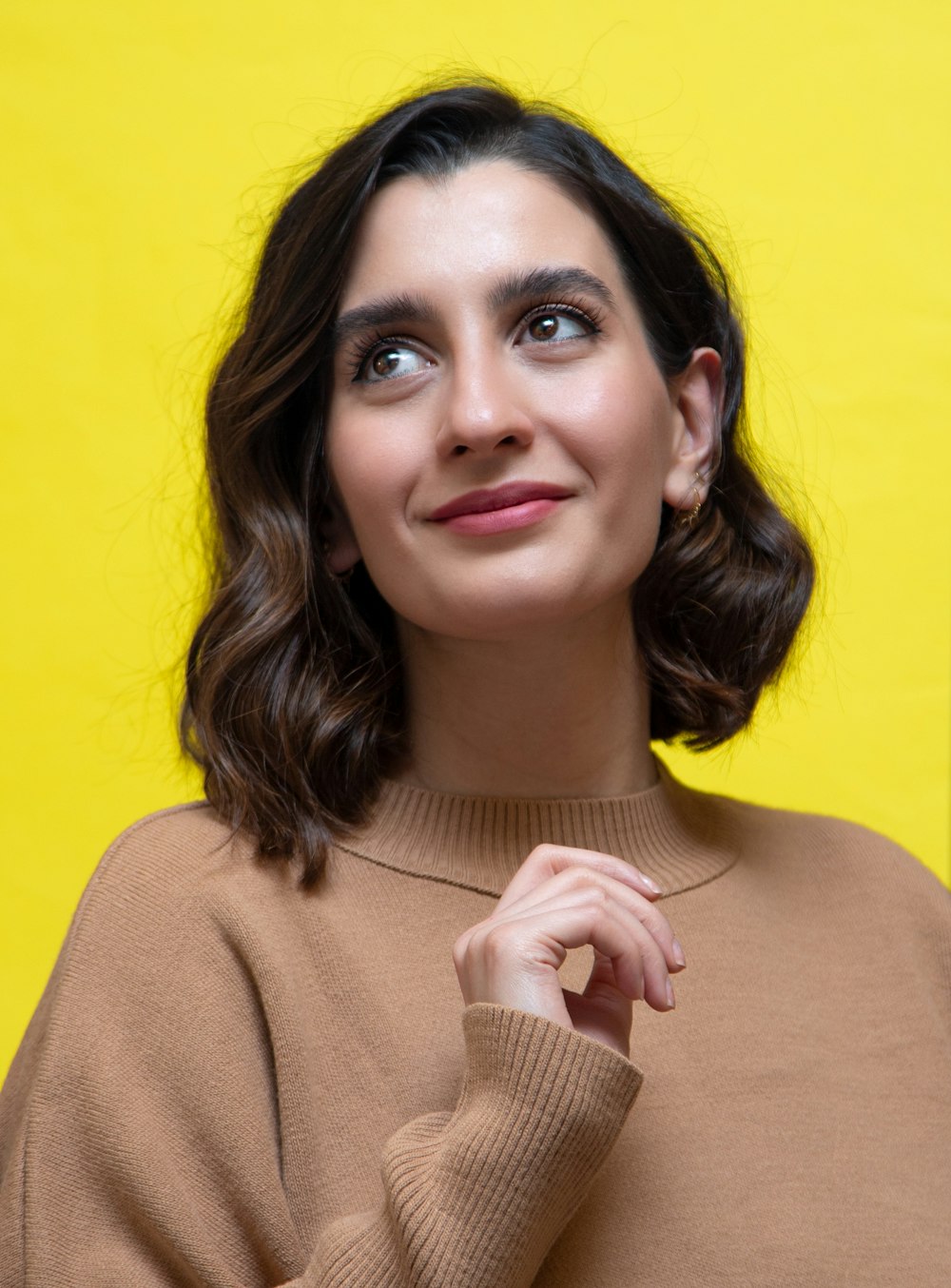 a woman in a brown sweater posing for a picture